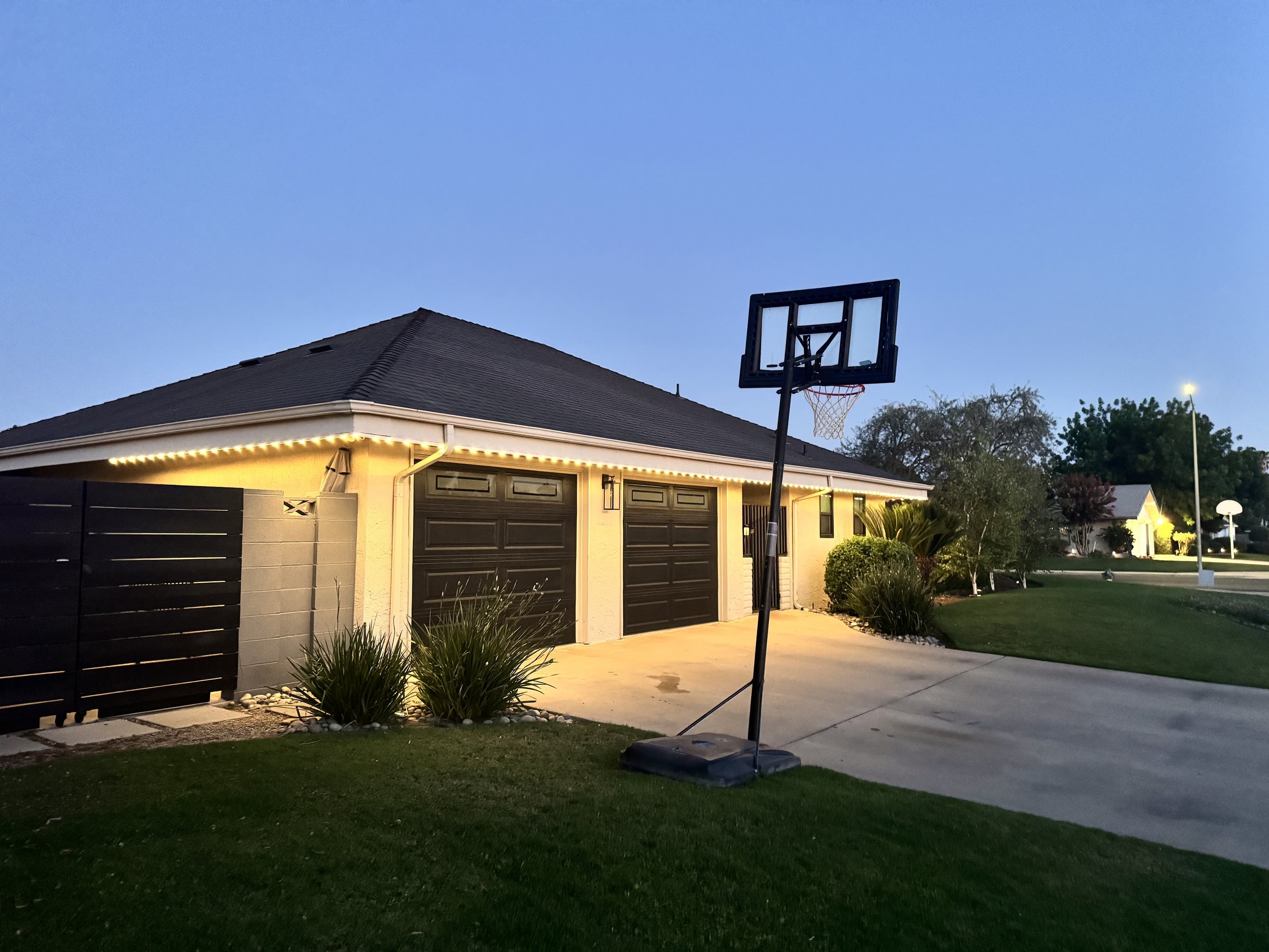 Garage and driveway roofline lit by EverLume permanent lighting